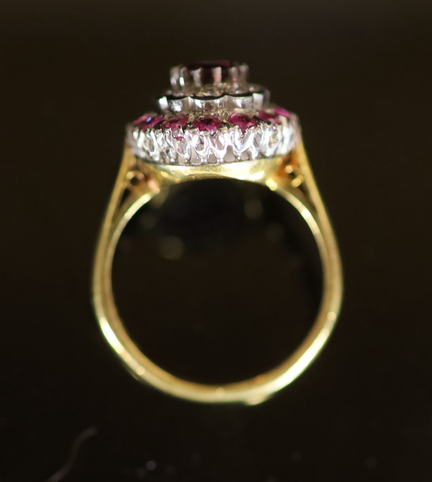 A modern 18ct gold, ruby and diamond set oval cluster ring